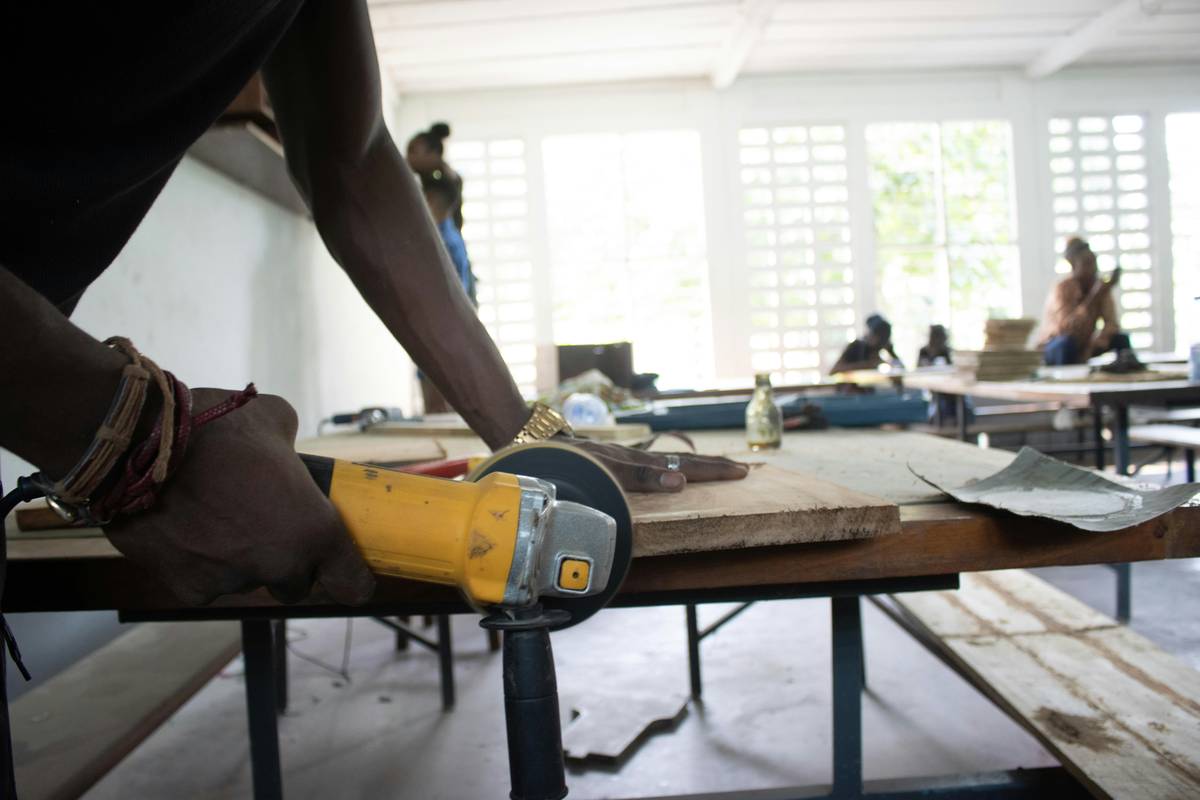 A person using a circular saw to cut a piece of wood